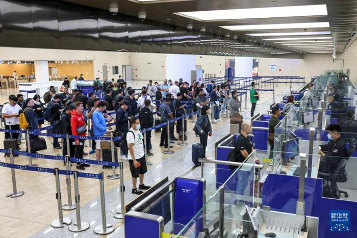  10月25日，旅客在青岛胶东国际机场入境边检大厅排队候检图：新华社